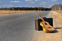 دانلود عکس استوک چمدان و گیتار در جاده