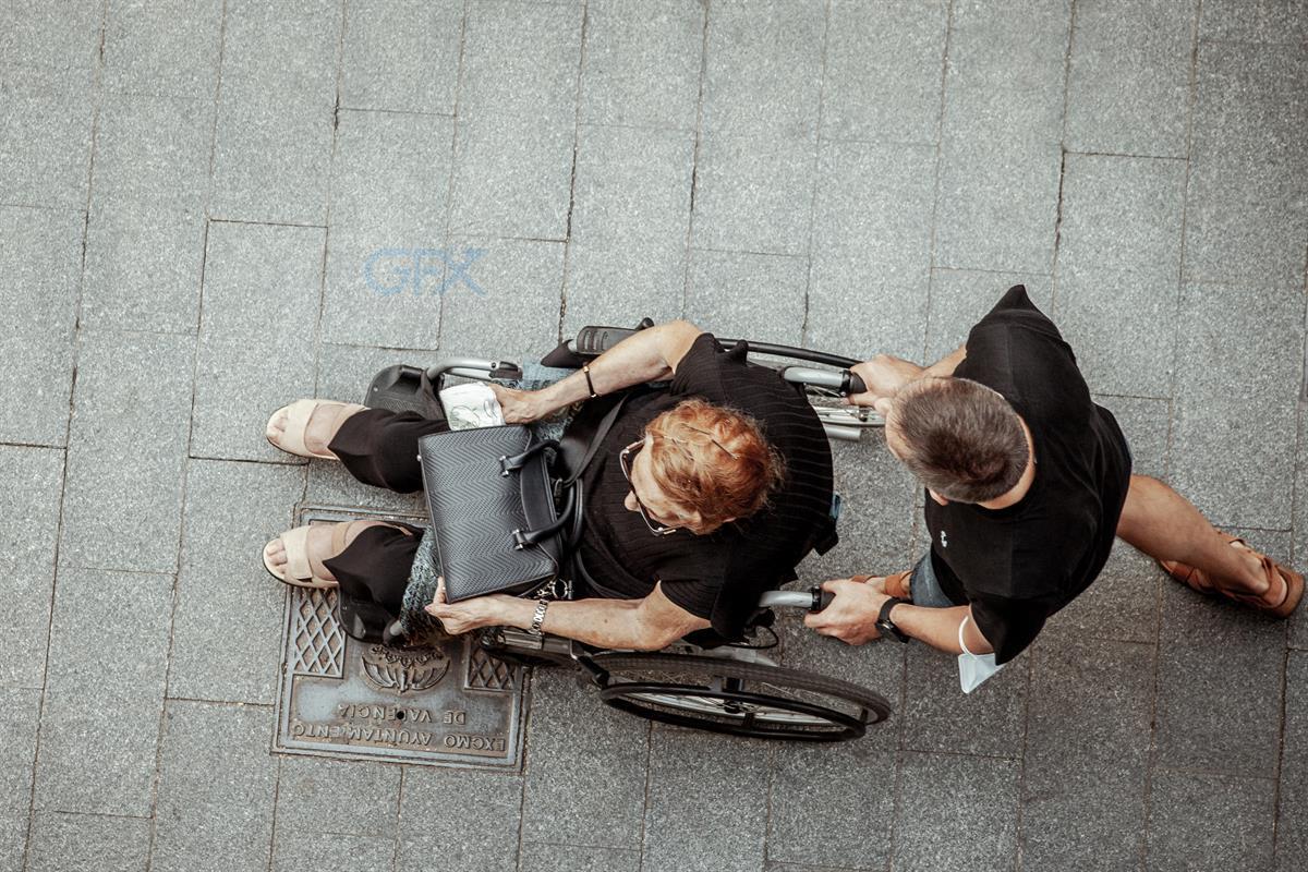 عکس هوایی Overhead shot از کمک به فرد با Wheelchair