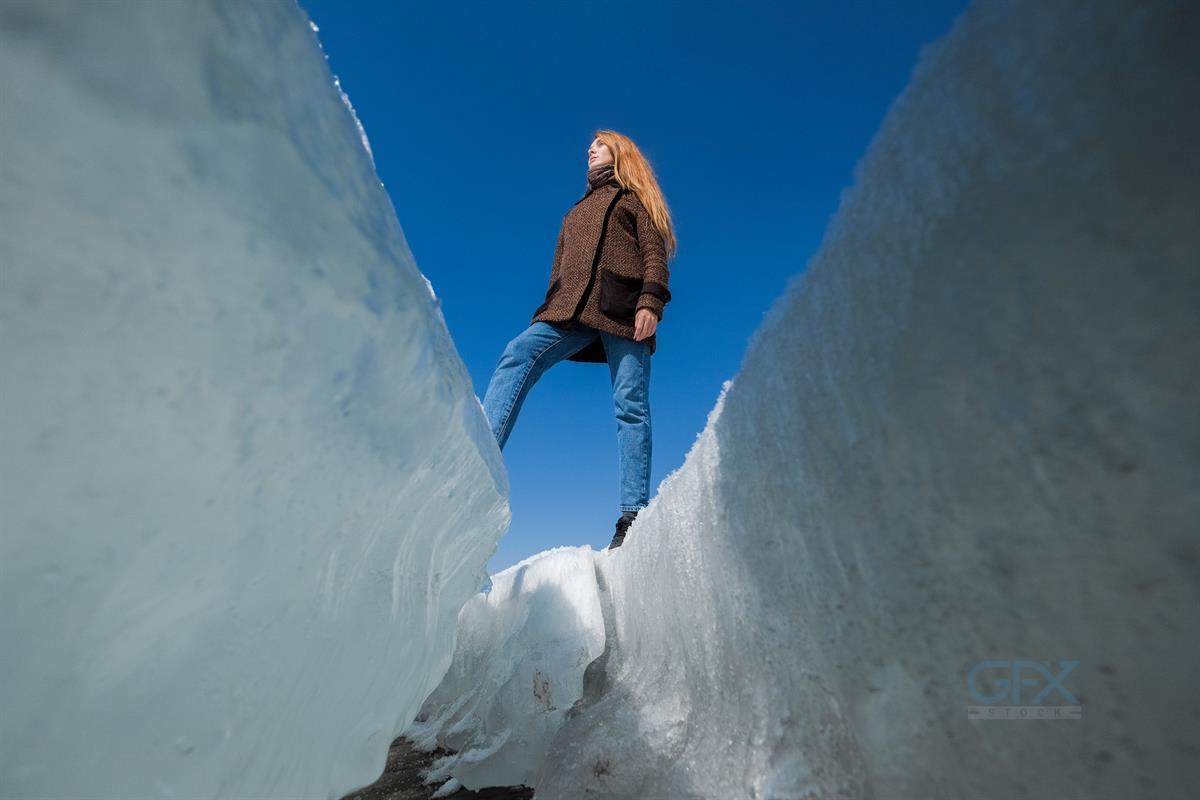 A Woman On The Background Of Broken Ice Covering The Lake.