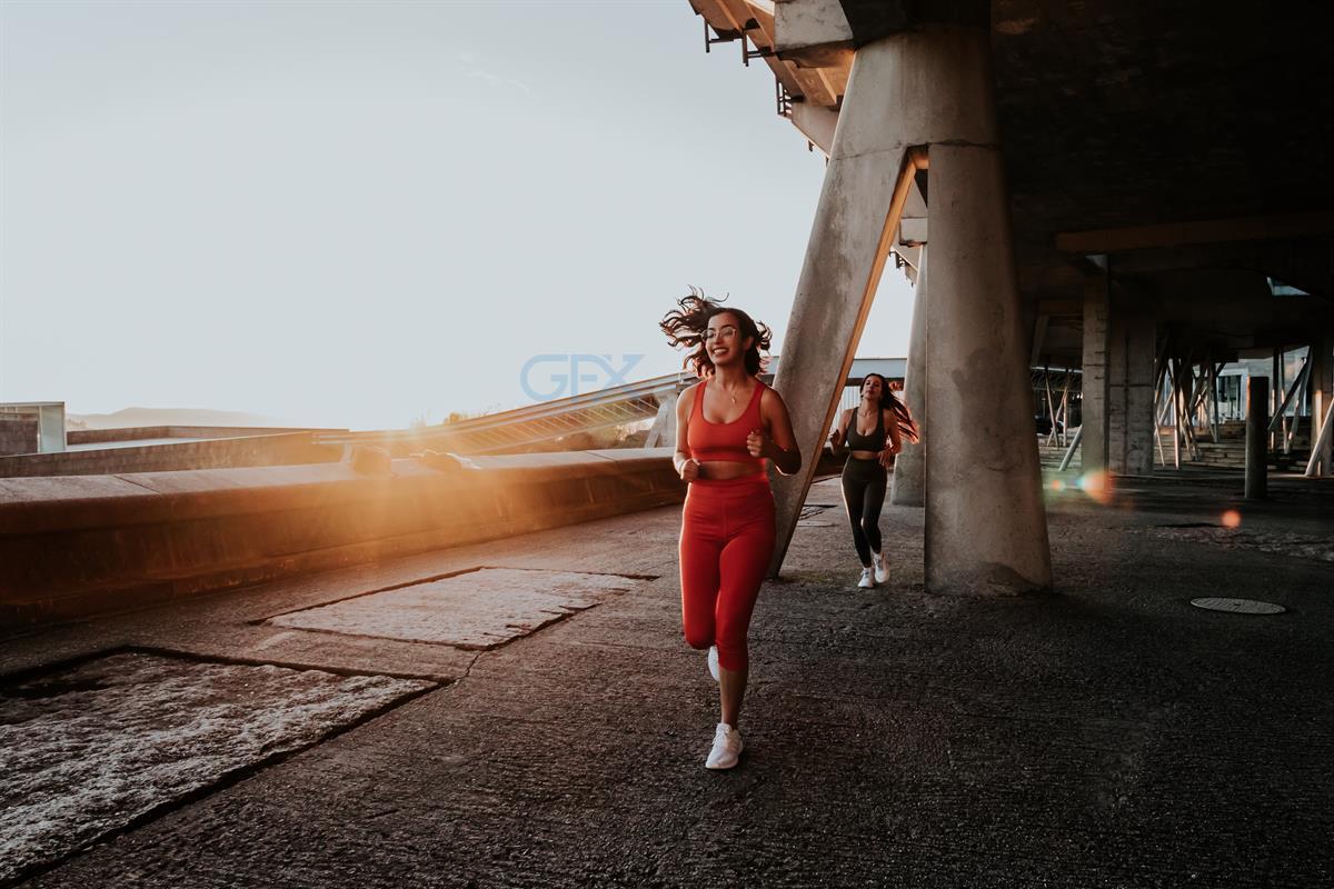 دو زن ورزشکار Running در طلوع آفتاب - Urban Fitness