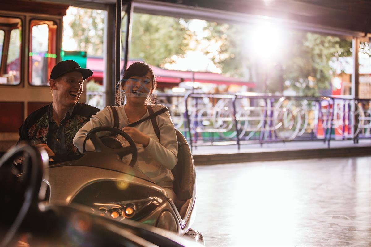 دانلود عکس مرد و زن در Bumper Car شهربازی | Young Man and Woman Stock Photo