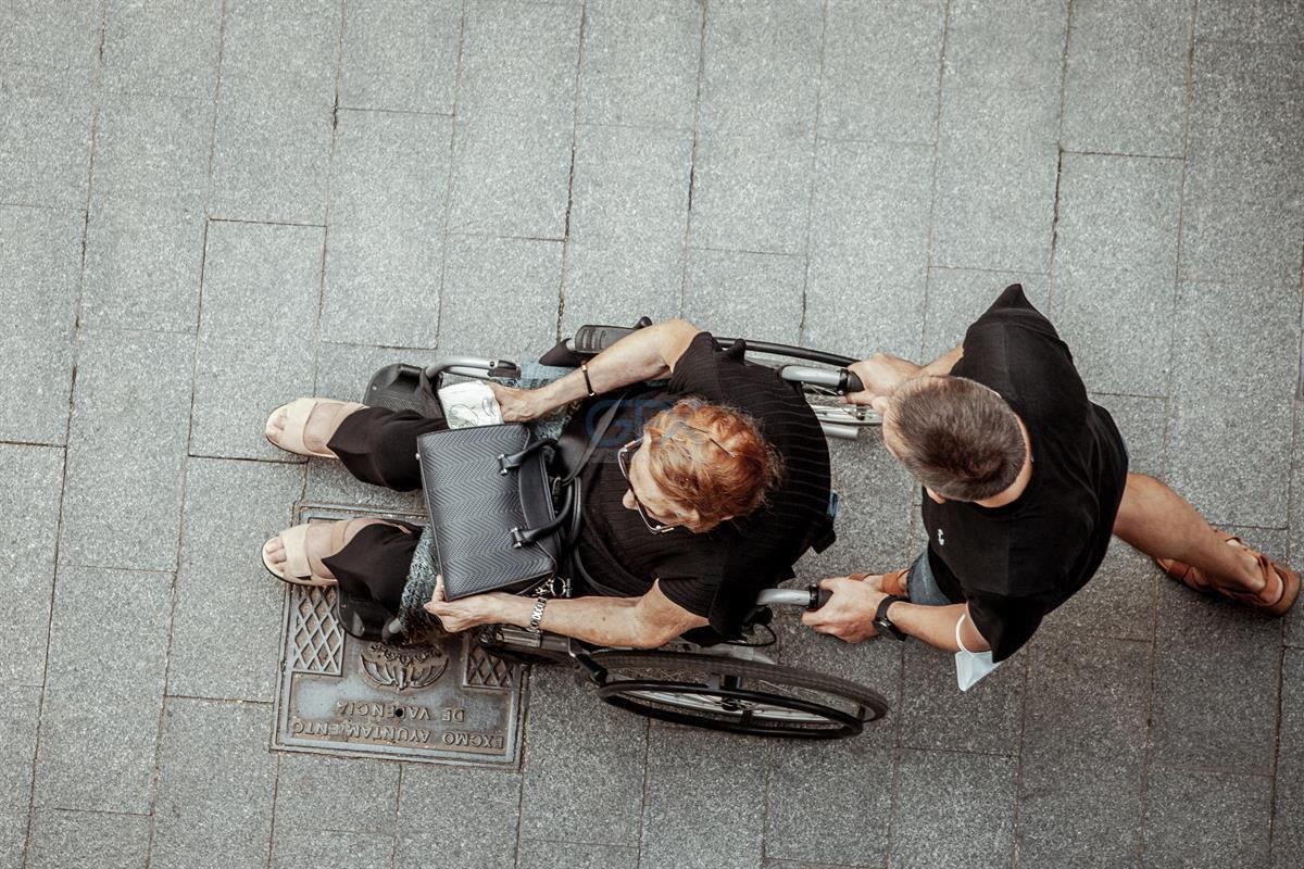 عکس هوایی Overhead از زن و Wheelchair در پیاده‌رو